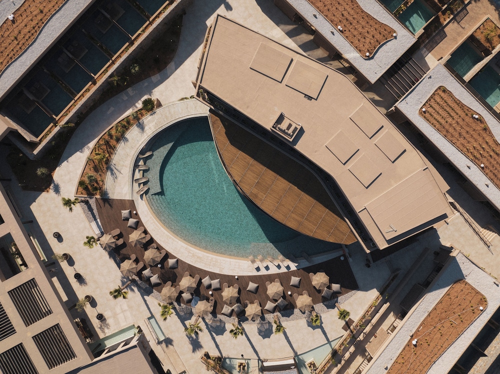 Modern luxe resort met zwembad, ligbedden en zonterras vanuit luchtperspectief